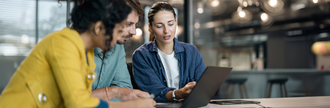 Co-workers discussing presentation on a laptop