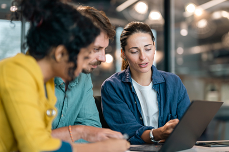 Co-workers discussing presentation on a laptop