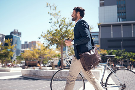 Employee walking a bicycle to an office