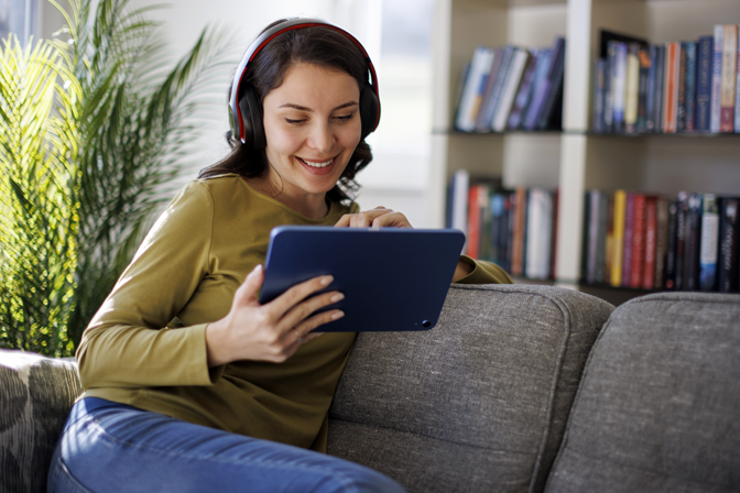 Person sitting on couch reading a computer tablet
