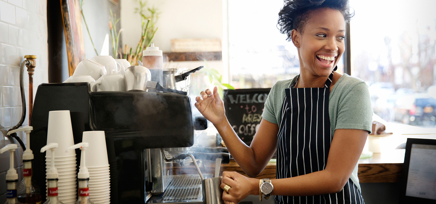 barista smiling while steaming milk