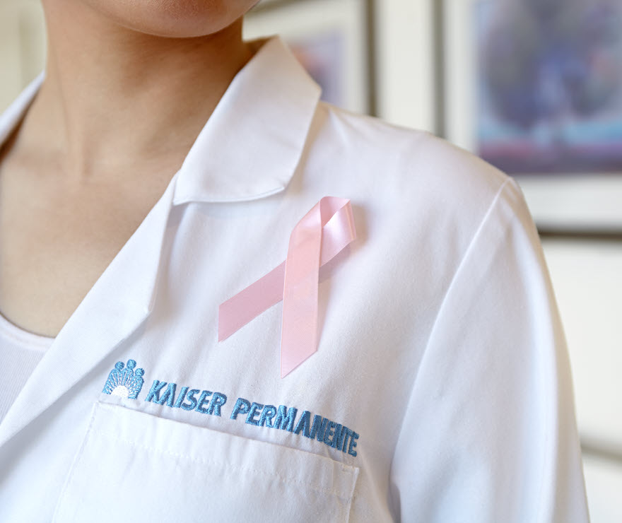 Doctor‘s coat with a pink ribbon and Kaiser Permanente logo on it