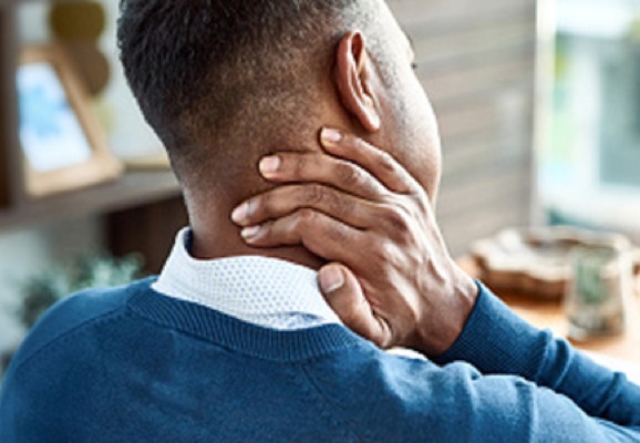 A man holds his neck in pain